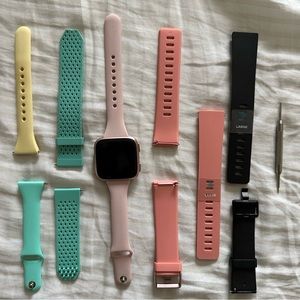 Fitbit Versa with assorted bands and charger